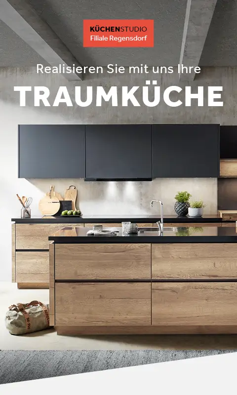 Moderne Küche in Holz und Schwarz mit Kochinsel unter Betonoptik-Decke. Küchenutensilien und Pflanzen dekorieren die Arbeitsfläche. Ein beiger Stoffbeutel steht am Boden.