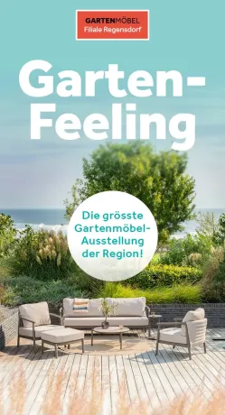 Moderner Outdoor-Loungebereich auf heller Holzterrasse. Beigefarbene Gartenmöbel (Sofa, Sessel, Hocker) um runden Tisch. Im Hintergrund üppige Grünpflanzen und Meer unter blauem Himmel für entspannte Atmosphäre.