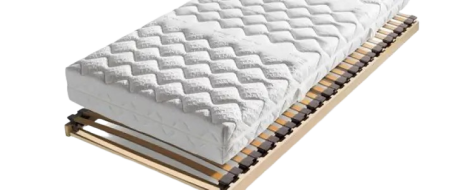 Eine weiße Matratze mit gestepptem Muster liegt auf einem Lattenrost aus hellem Holz. Schwarze Kunststoffhalterungen verbinden die Latten. Der Hintergrund ist weiß.