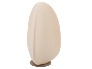 Beige, eiförmige Skulptur auf rundem, grauem Sockel, leicht nach links geneigt. Ein sanfter, vertikaler Grat akzentuiert die linke Seite der Form.