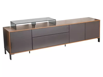 Ein langes, niedriges Sideboard in Braun und Grau steht auf schlanken, dunklen Beinen. Ein Glasregal liegt auf der linken Seite des Sideboards. Es hat Schubladen und Schranktüren.