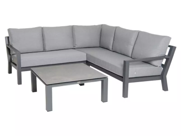 Ein graues Ecksofa mit grauen Kissen und einem grauen Tisch auf weißem Hintergrund.