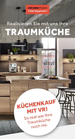 Moderne Küche mit Kochinsel aus Holz, zwei Barhockern und Regalen an der Wand. Drei Hängelampen hängen von der Decke. Ein Fenster gibt den Blick auf Gebäude frei.
