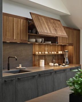 Moderne Küche in Grau und Holz mit geöffnetem Hängeschrank, Geschirr, Armatur und Küchengeräten.